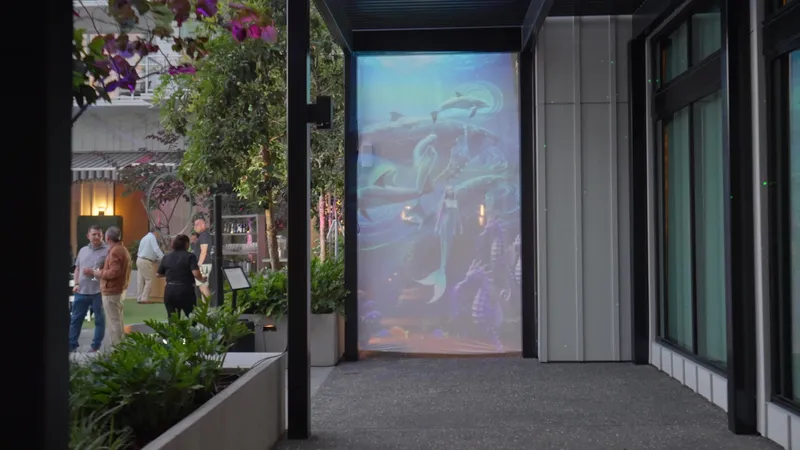Guests at Mission Pacific Hotel beside an illuminated underwater-themed projection installation